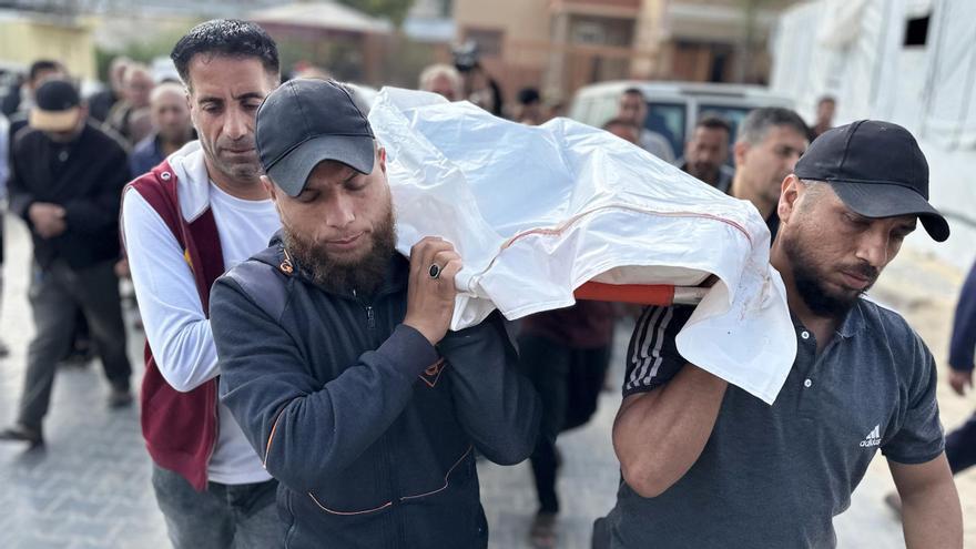 Hombres trasladas a una víctima de un ataque israelí en Gaza, en Jan Yunis.