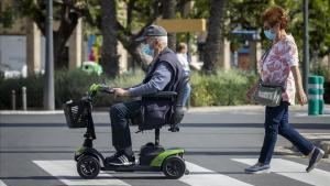 Dos personas mayores pasean por las calles de Valencia en el primer día en que pueden salir a dar una vuelta desde que se decretó el estado de alarma.