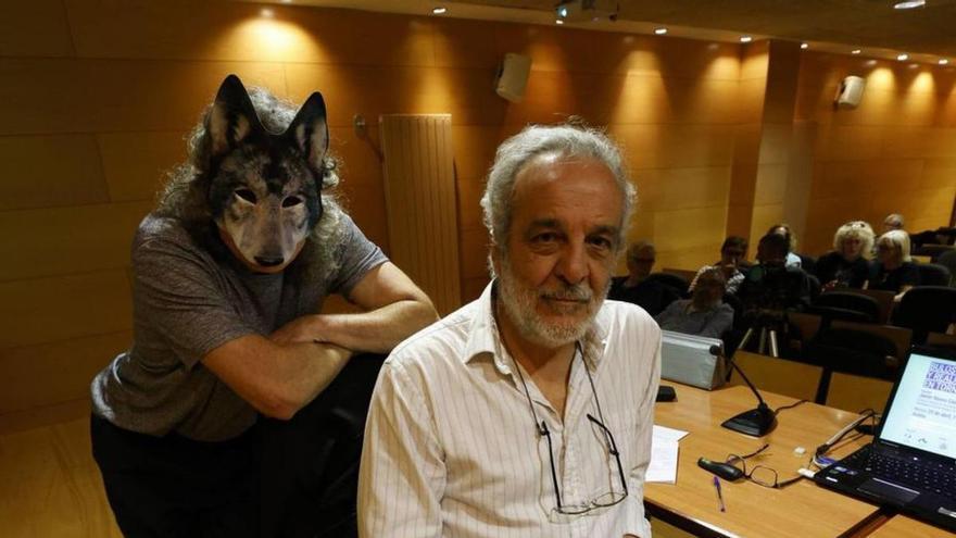 Javier Naves, durante la charla en Servicios Universitarios, con un miembro del colectivo ecologista con una careta de lobo.