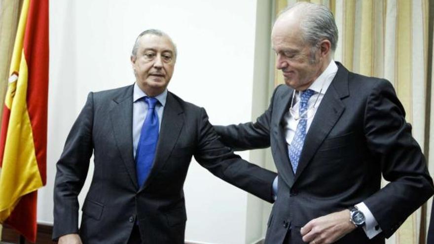 El presidente de Renfe, Julio Gómez-Pomar (izquierda), y el de Adif, Gonzalo Ferre,     se saludan al llegar a la comisión del Congreso.  // Efe