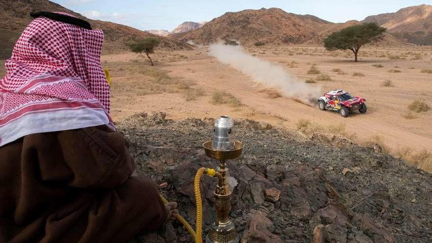 Un saudí observa el paso del coche de Carlos Sainz. // Andre Pain