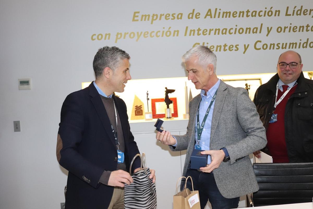 El presidente de la comisión de Colegiación, Julio Bel, entrega un regalo a Rafael Juan.