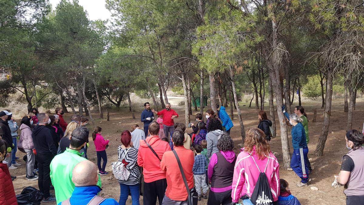 Uno de los organizadores da las indicaciones para la limpieza del pinar que hay junto al centro.