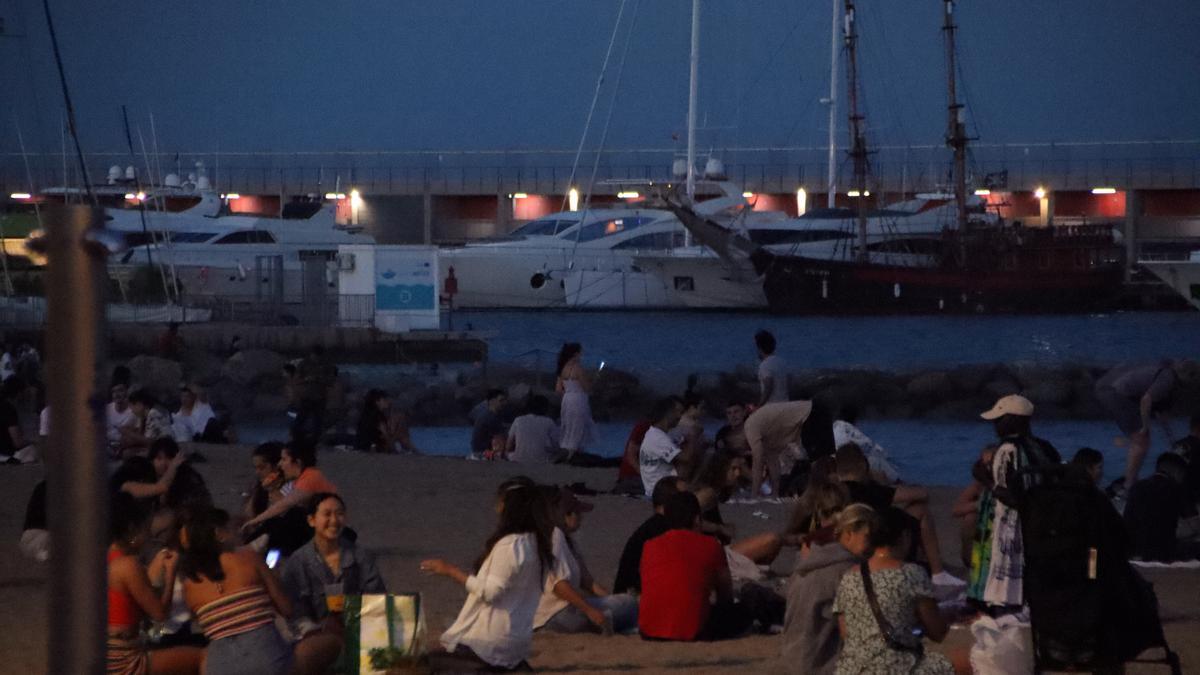 Un grup de gent sopa a la platja del Somorrostro de Barcelona a la revetlla de Sant Joan