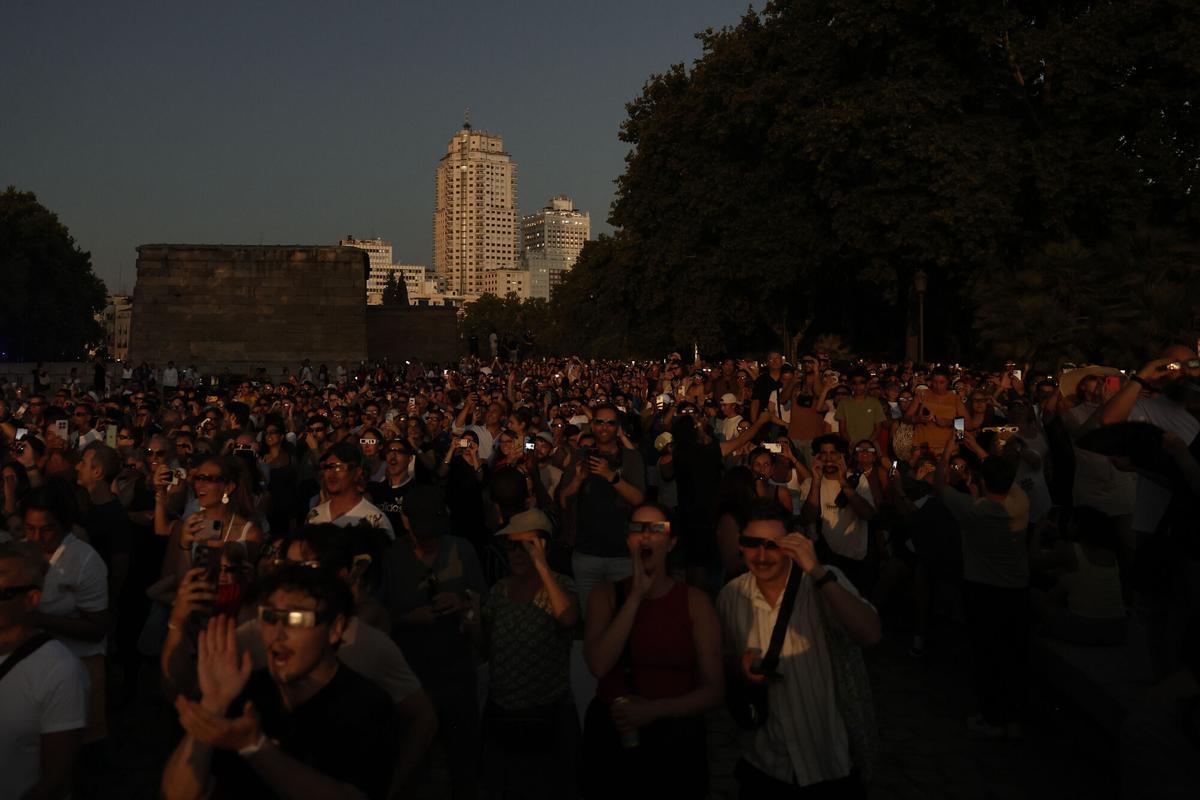 Miles de personas atienden al eclipse solar este miércoles en Madrid