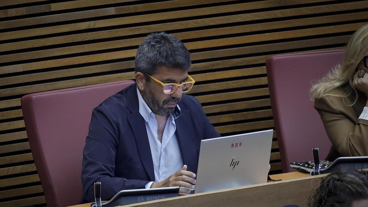 El expresident de la Generalitat, Carlos Mazón, trabaja ante el ordenador en su escaño.