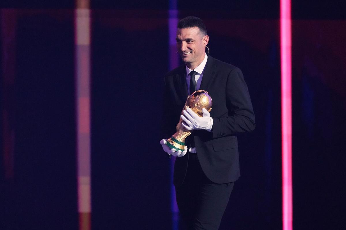 Lionel Scaloni, el seleccionador de Argentina, vigente campeón, por el trofeo dorado al escenario durante la ceremonia del sorteo del Mundial-2026.