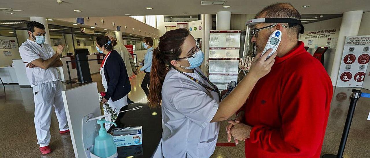 Toma de temperatura a un usuario en la entrada del Hospital del Vinalopó en Elche. ANTONIO AMORÓS