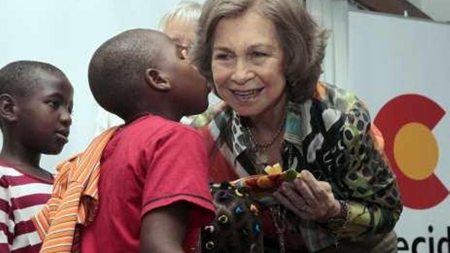 La Reina recibe un obsequio de un niño en Maputo.