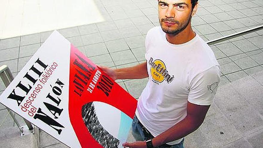 Eduardo Begega muestra el cartel con el que ganó el concurso del Descenso Folclórico del Nalón.