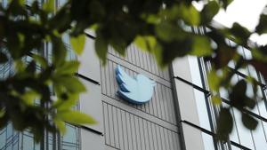 Workers remove letters from the iconic vertical Twitter sign after Elon Mus rebrands as X