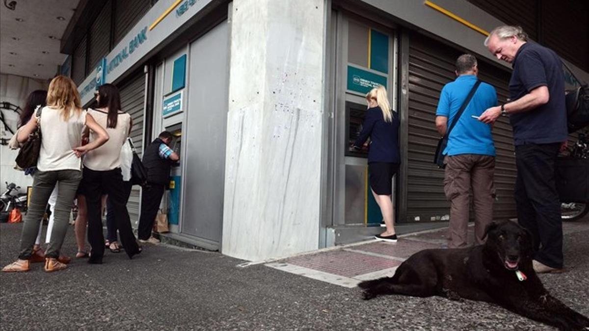 Cola de ciudadanos frente a los cajeros automáticos del Banco Nacional de Grecia, en Atenas