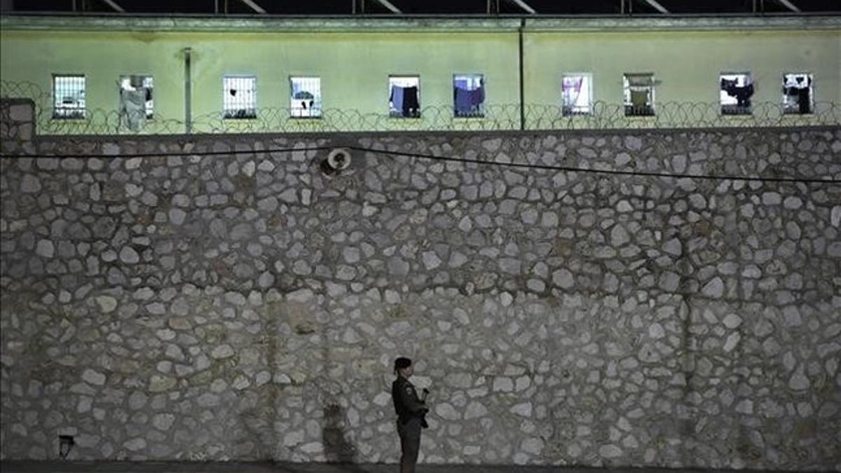 Fotografía de archivo de un agente de policia haciendo guardia frente la cárcel de Korydallos, en Atenas.