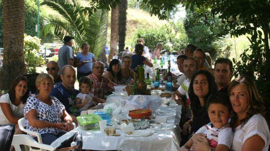 Sobre estas líneas, vecinos de  Santarúa en la comida en el parque. A la derecha, Silvina Castro y Mari Rodríguez, con otros comensales. | b. f.