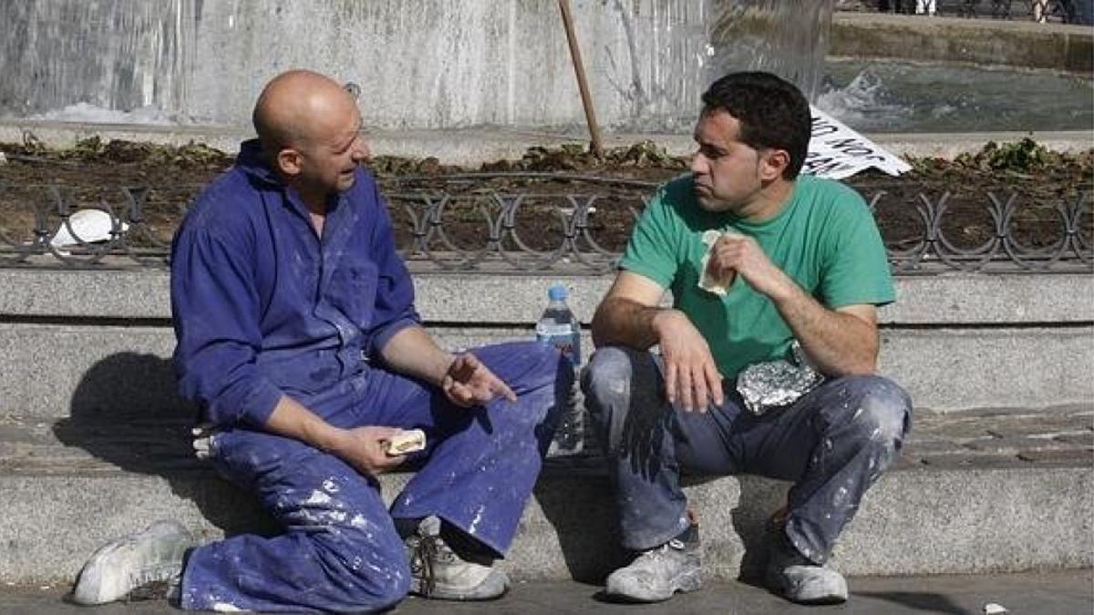 Dos trabajadores se toman su pausa de media mañana para el tetempié.