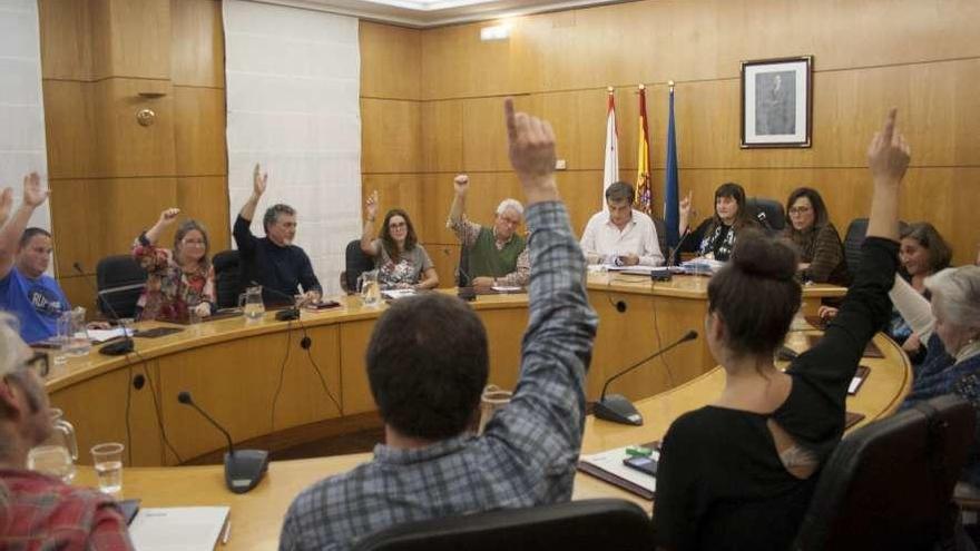 Los ediles del PSOE y Somos, con los brazos en alto para apoyar la modificación de crédito.