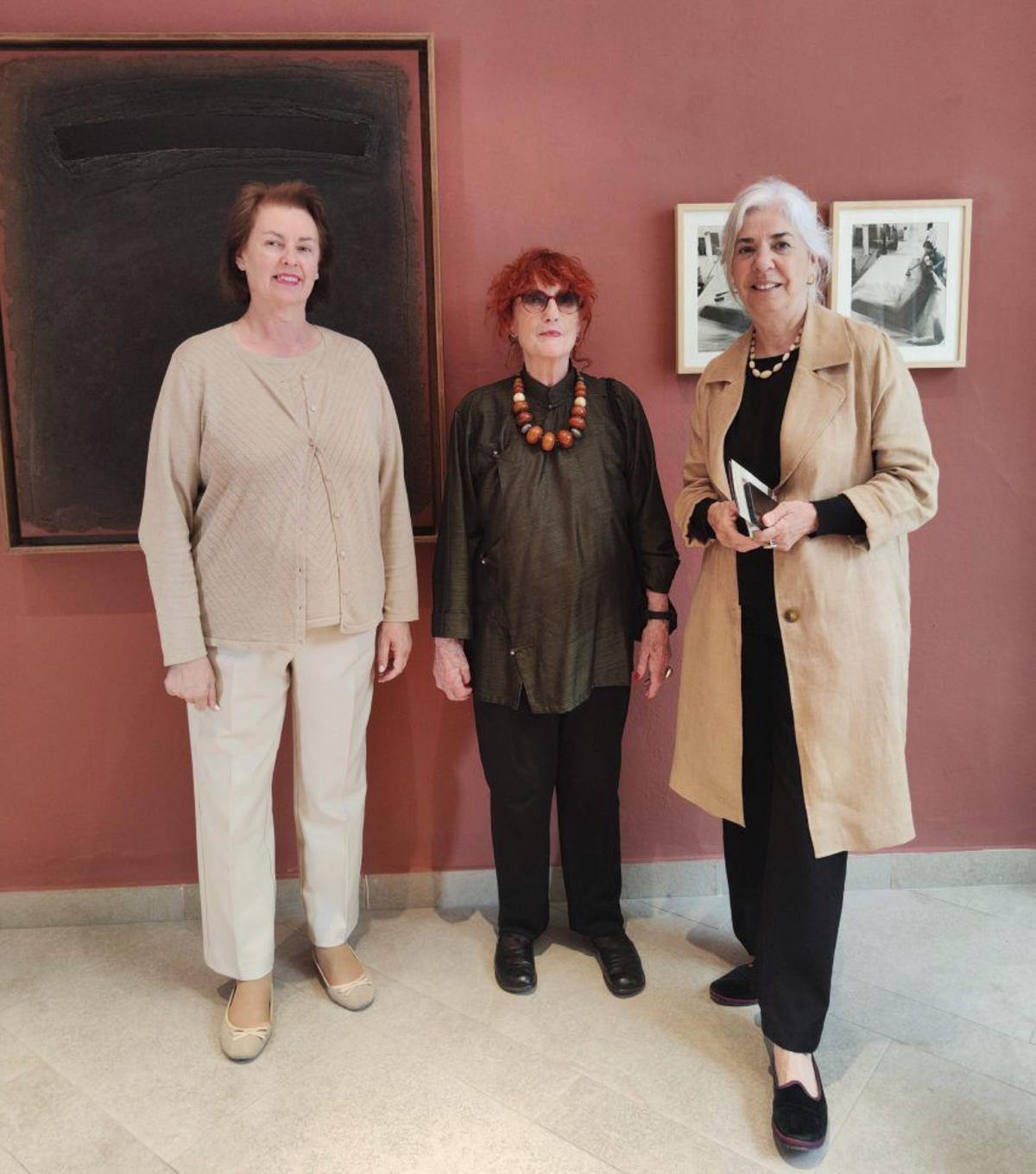 Carmen Domínguez, Christina Bechtold y Elena Ruiz ante una obra de Bechtold y dos fotos de Häusser en las que retrata a Erwin Bechtold pintando una obra en su estudio. | ROBERT HÄUSSER