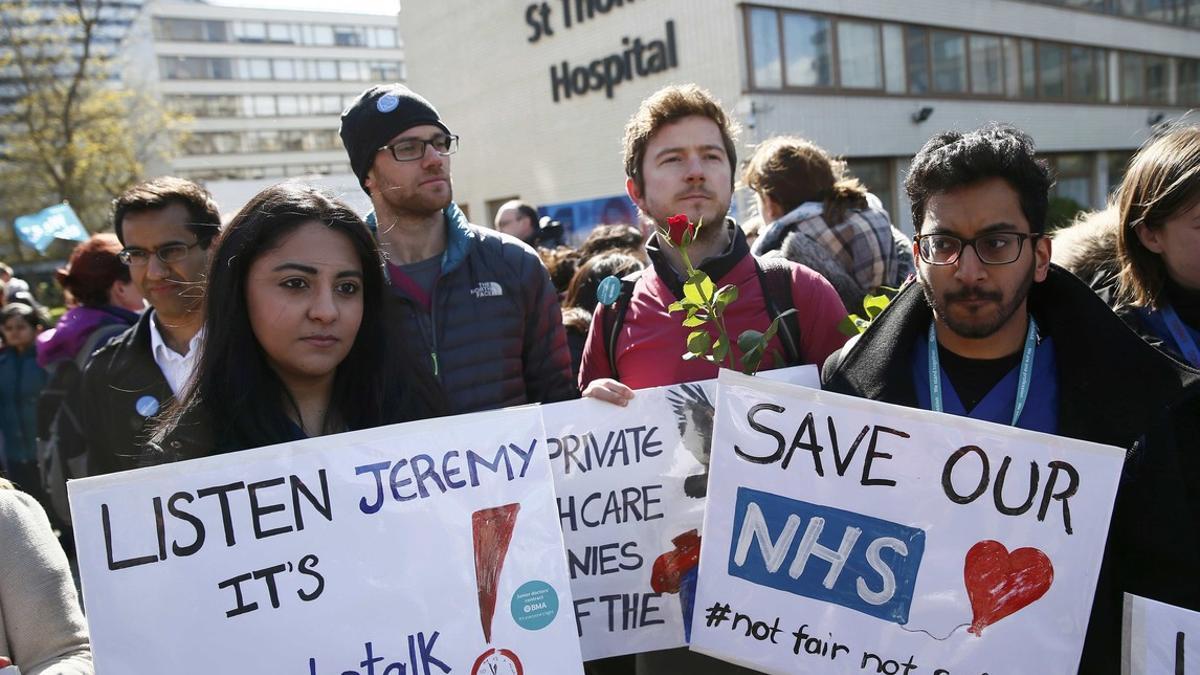 Junior doctors and supporters hold placards during a strike outside St Thomas' Hospital in London