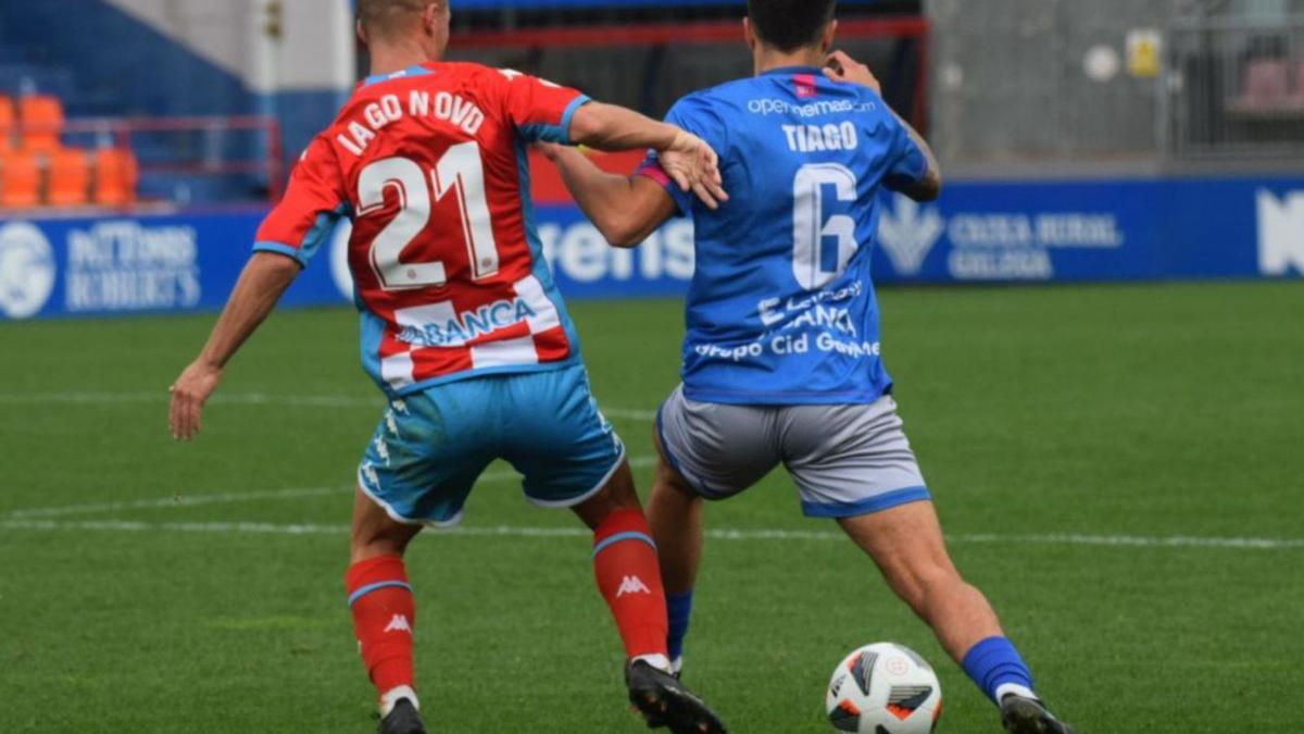 Iago Novo, del Polvorín, y Tiago, del Ourense CF, disputándose el esférico en el Anxo Carro. |  // OURENSE CF