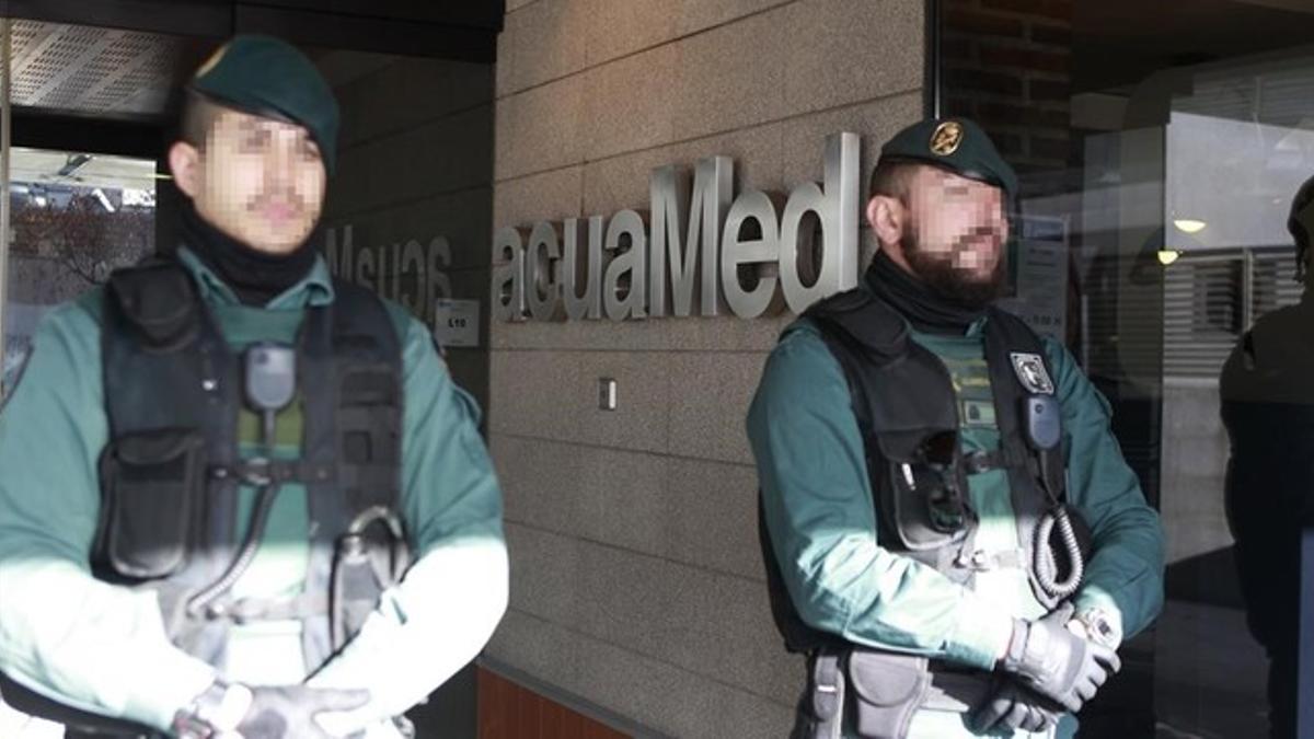 Agentes de la Guardia Civil custodian la sede de la empresa pública Aguas de las Cuencas Mediterráneas (Acuamed), en Madrid, durante el registro de las dependencias.