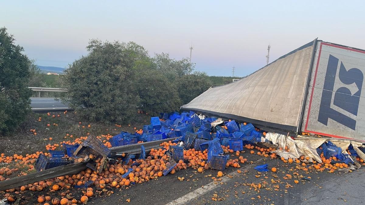 El camión volcado y la carga esparcida.