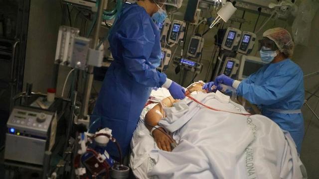 Hospital staff members treat a patient suffering from the coronavirus disease (COVID-19)  in the Intensive Care Unit (ICU) at the Hospital Clinic  after Catalonia s government imposed new restrictions in an effort to control a COVID-19 third wave  in Barcelona  Spain February 3  2021  REUTERS Nacho Doce