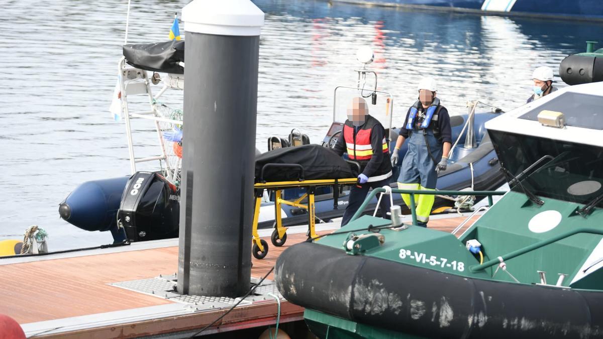 Efectivos de emergencias descargan de la patrullera Mar de Galicia el cuerpo aparecido en Punta Herminia