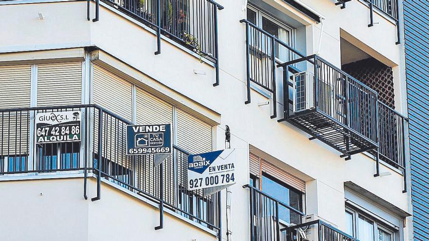 Carteles de venta en el balcón de una vivienda en Cáceres.