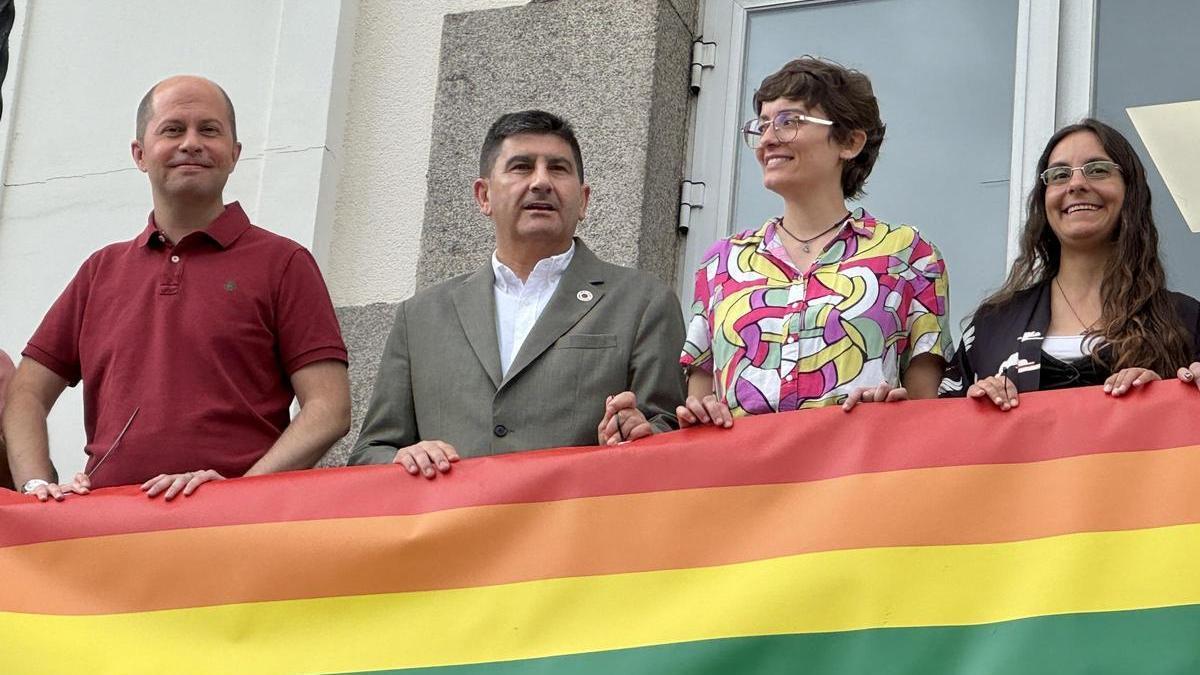 El delegado del Gobierno en Galicia, Pedro Blanco (centro), en el balcón de la Delegación del Gobierno en A Coruña, donde se ha colocado una bandera LGTBIQ+ con motivo del mes del Orgullo.