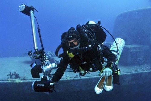Un fotógrafo y una modelo trabajan bajo el agua en una sesión fotográfica de moda