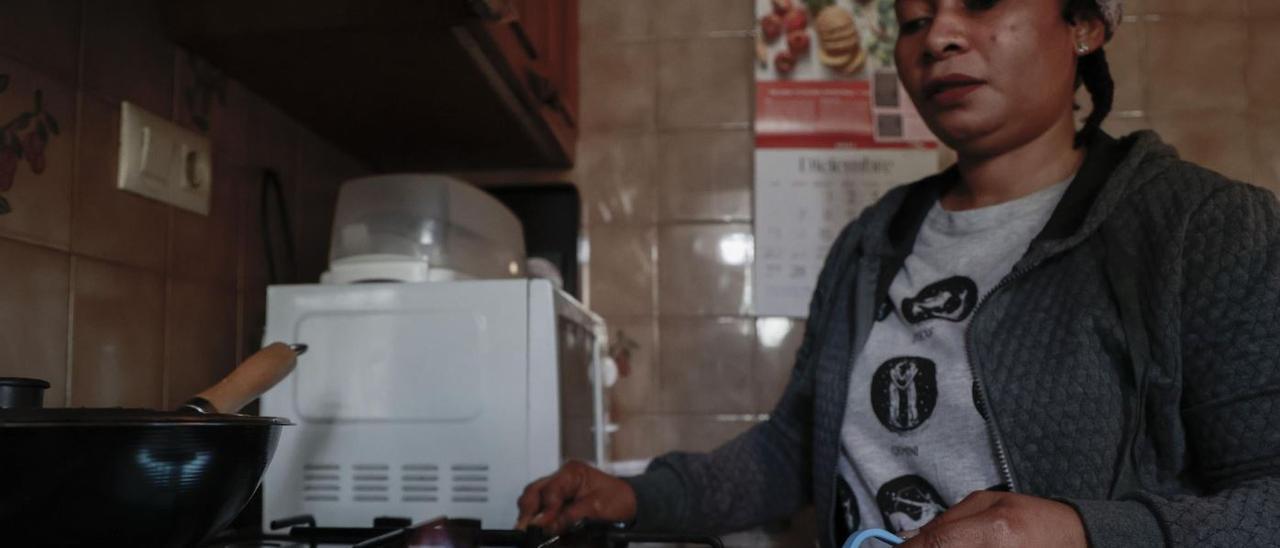 Una madre del barrio valenciano de Fuensanta, usando su cocina a gas.