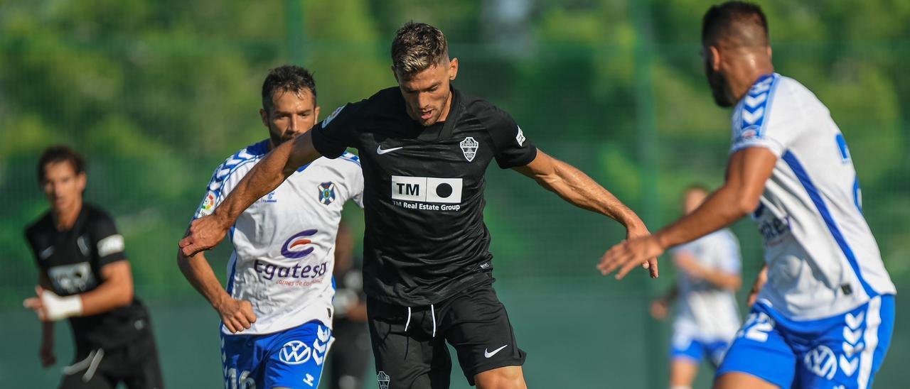 Boyé conduce un balón entre jugadores del Tenerife. | SONIA ARCOS/ECF