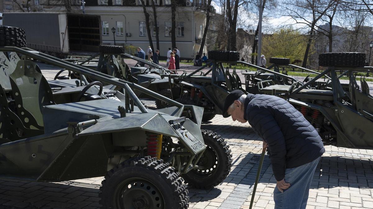 Un hombre mayor mira en Kiev un moderno vehículo del Ejército ucraniano.