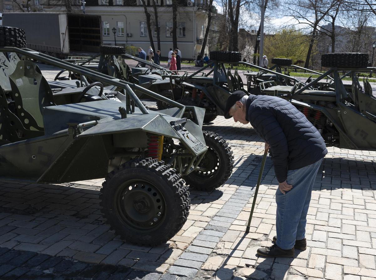 Un hombre mayor mira en Kiev un moderno vehículo del Ejército ucraniano.