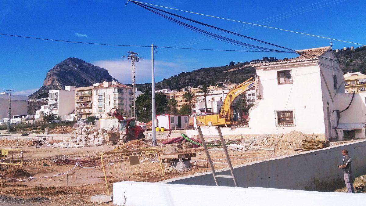 La máquina echa abajo la casa que está en los terrenos que se están urbanizando