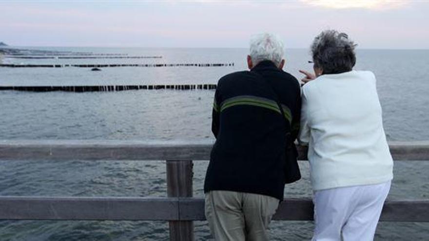 Dos personas ancianas disfrutan de las vistas.