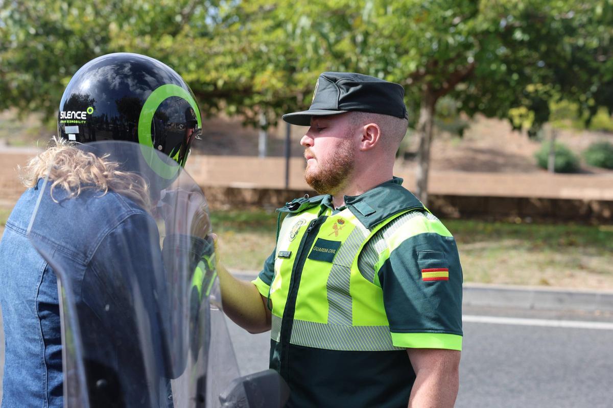 Un guardia civil realiza un test de alcoholemia a una motorista.