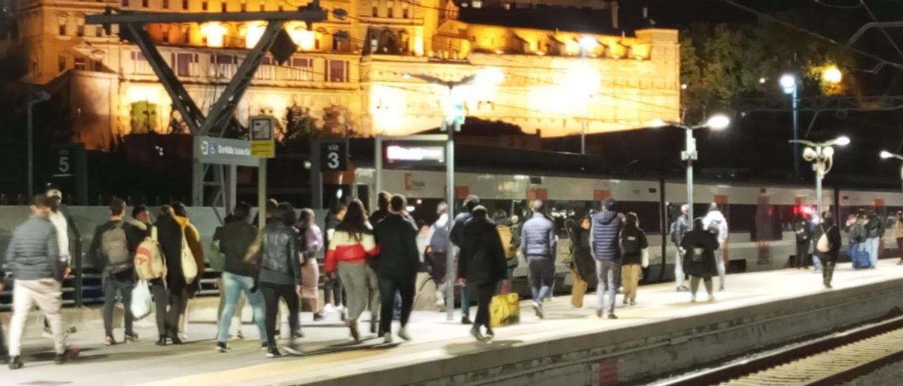 Passatgers de la Renfe anant a buscar el tren, que va arribar amb 40 minuts de retard, diumenge al vespre