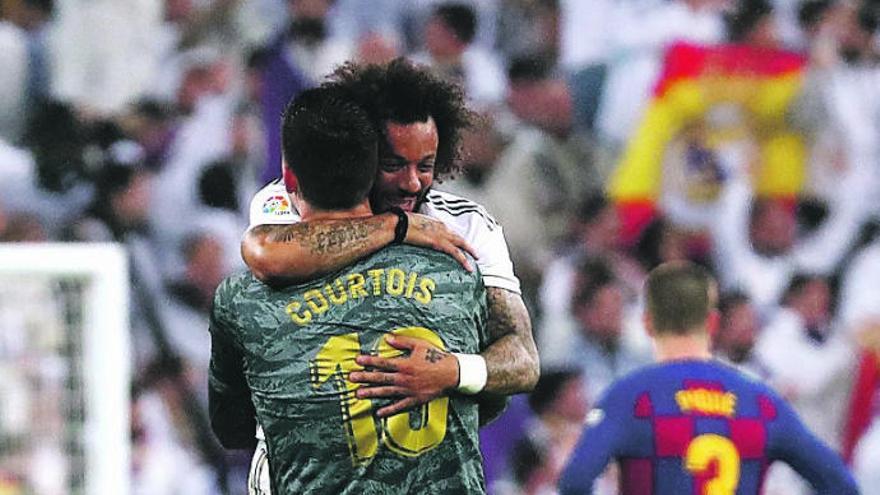 Courtois y Marcelo se abrazan en el clásico.