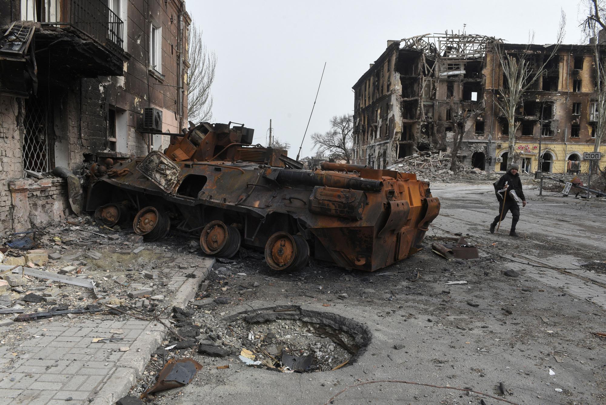 Un hombre pasa junto a un tanque quemado en la ciudad de Mariúpol