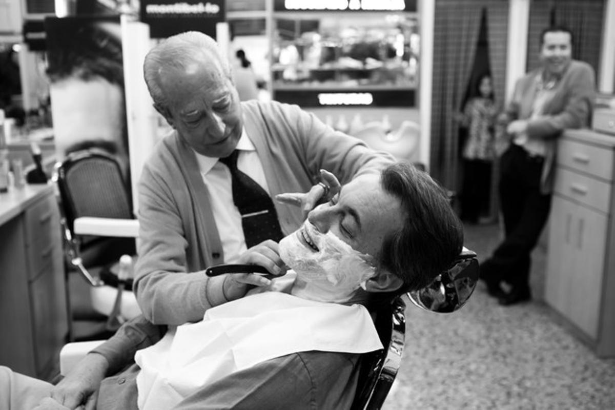 La càmera sorprèn el candidat quan el seu barber el prepara per a la foto final.