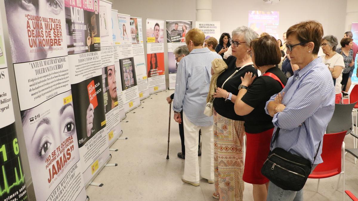 Varias mujeres observan las diferentes campañas realizadas en la lucha contra la violencia de género