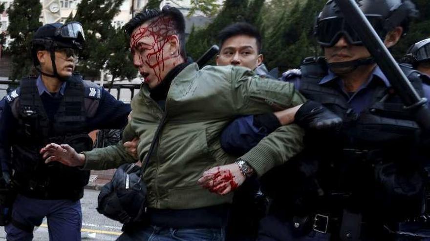 Un manifestante herido, detenido por antidisturbios. // Reuters