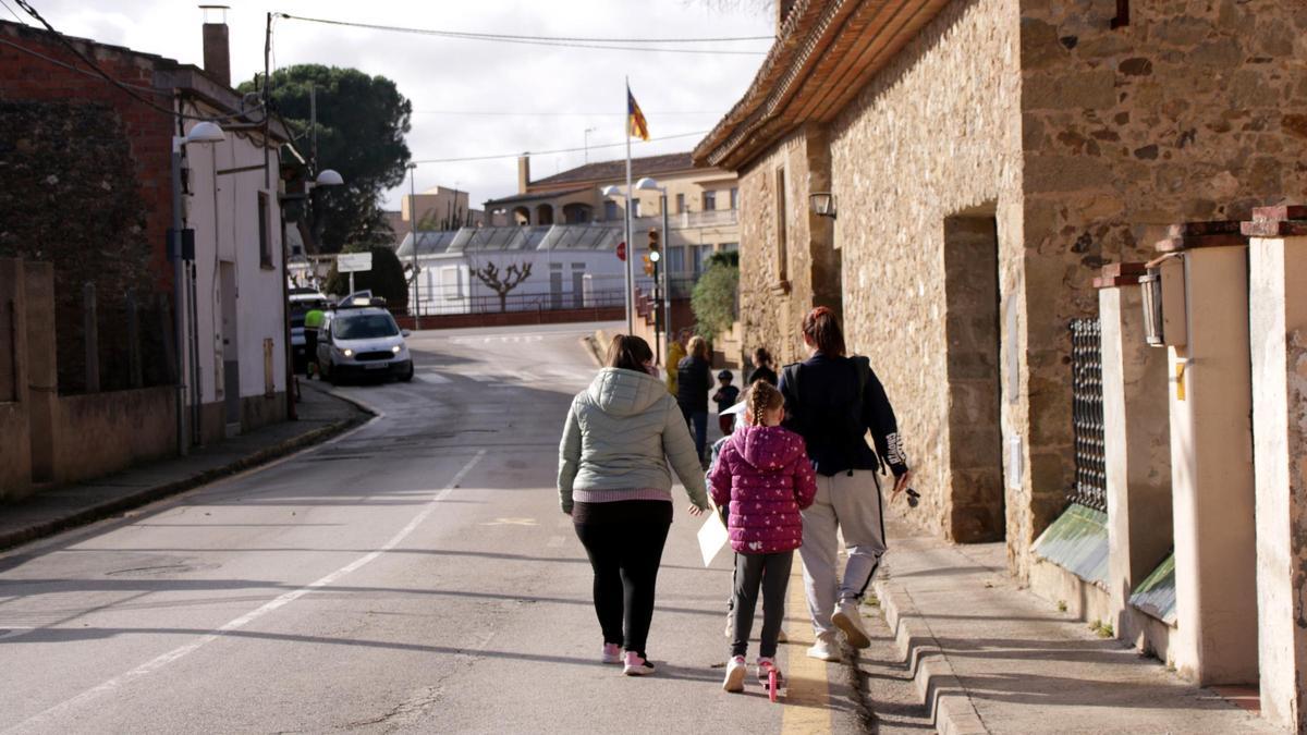 Un grupo de niños y padres camino hacia el segundo edificio de la escuela de Corçà