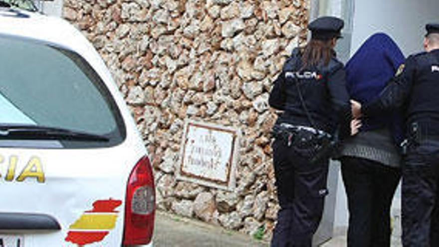 Dos policías custodian a la mujer que confesó haber matado a su hijo, ayer en Maó.