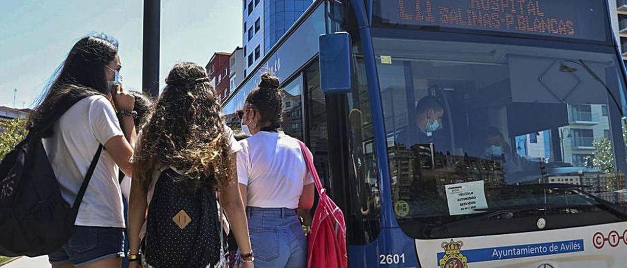 Tres chicas se suben a un autobús en Avilés.