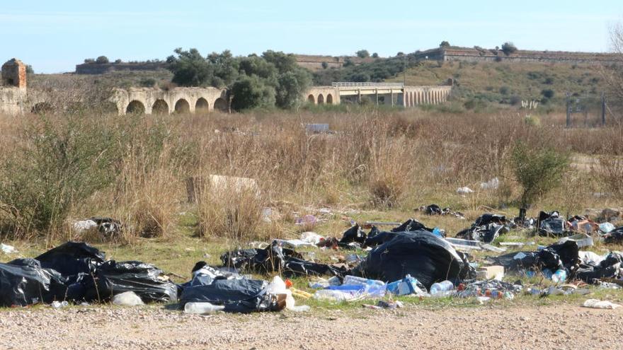 Restes de deixalles a la zona amb els arcs del Castell de Sant Ferran de fons ·