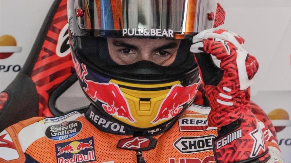 Márquez bajándose la pantalla de su casco en su box