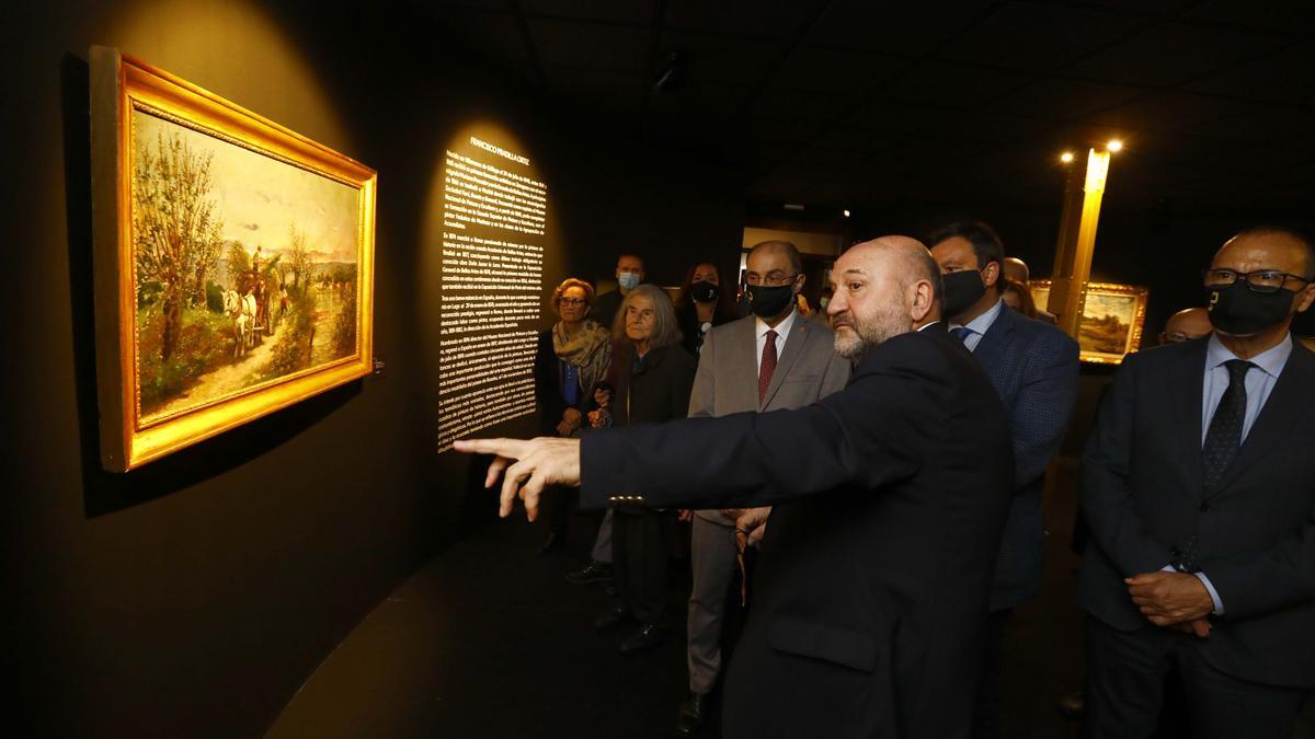 El historiador del arte Wilfredo Rincón explica a Lambán, a la nieta de Pradilla y al resto de asistentes el discurso expositivo del nuevo espacio creado en Villanueva.