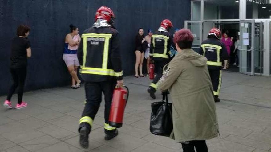Llegada de los bomberos al edificio, con usuarios y trabajadores ya evacuados.